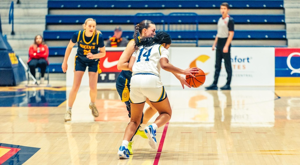 Anika Fermin drives against the Queen's defender - Hector Perez